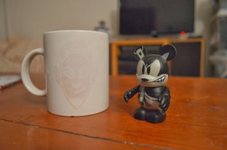 A photo of a cup and a figurine.